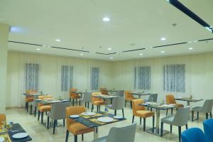 阿可贺巴Safwat Alkhobar Hotel的餐厅内带桌椅的用餐室
