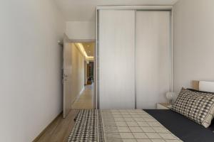 塞萨洛尼基Central Luxury Apartment的卧室设有白色墙壁、一张床和走廊