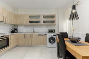 塞萨洛尼基Central Luxury Apartment的厨房配有洗衣机和木桌。
