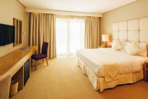 长滩岛卡米拉海滩度假村别墅的酒店客房设有一张大床和一台电视。