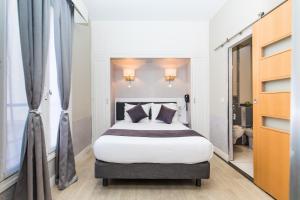 巴黎HOTEL DE PARIS MONTPARNASSE的一间卧室,卧室内配有一张大床