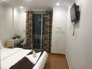 西哈努克LK Apartment & Hotel的酒店客房,配有床和电视
