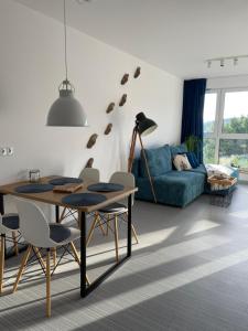 别尔斯克-比亚拉Apartamenty Beskid House的客厅配有桌子和蓝色沙发