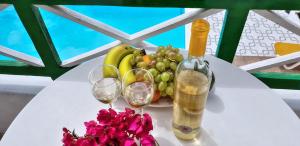 卡门港伊莎贝尔公寓酒店的一张桌子,上面放着两杯葡萄酒和一篮水果