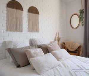 Home By Sab的白色卧室配有带枕头的床