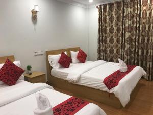 西哈努克LK Apartment & Hotel的酒店客房设有两张床和窗户。