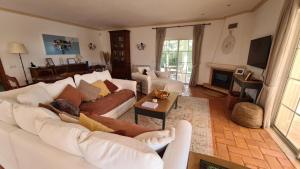 拉戈阿Peaceful 4BR villa on Gramacho golf resort w/ private pool的客厅配有白色的沙发和桌子上的猫