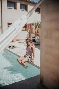 Salem格兰哈圣米格尔酒店的坐在游泳池边的小女孩