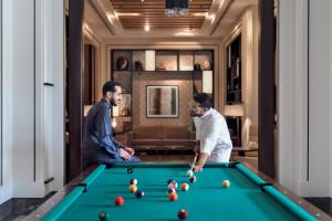 吉达Crowne Plaza - Jeddah Al Salam, an IHG Hotel的两名男子在旅馆房间打台球
