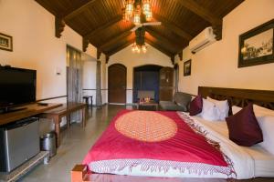 拉杰果德Heritage Khirasara Palace的一间卧室配有一张大床和一台平面电视