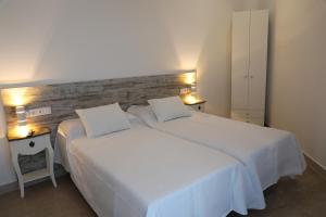 阿利坎特Pension Campello The Blue Med的卧室配有一张带两个枕头的大白色床