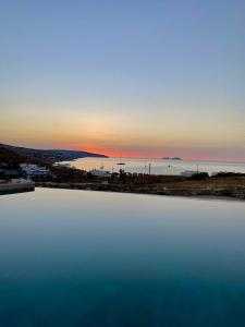 卡拉法蒂斯M-Vibes Mykonos Suites的一大片水,背景是日落