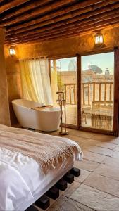 Misfāhنزل حارة المسفاة Harit AL Misfah Inn的一间带浴缸和大窗户的卧室
