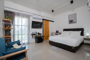 班泰Laewan Guesthouse的一间卧室配有一张床、一张桌子和一张沙发