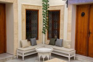 突尼斯Dar El Halfaouine的坐在建筑物边的白色长凳