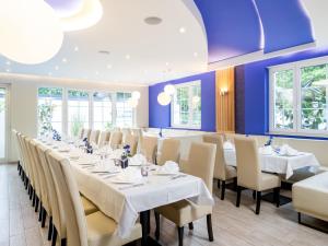 勒沃库森Kristallhotel Fettehenne的一间设有白色桌椅的大型用餐室
