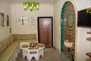 突尼斯Dar El Halfaouine的客厅配有桌子和沙发