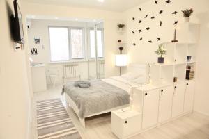 阿拉木图ADT apartments的白色的卧室设有一张床和一个墙上有鸟的架子