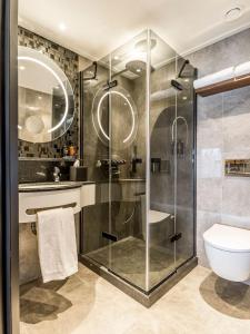 海滨诺德韦克亚历山大酒店的一间带玻璃淋浴和卫生间的浴室