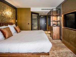 海滨诺德韦克亚历山大酒店的一间卧室配有一张大床和一台平面电视