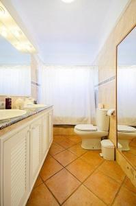卡亚俄萨尔瓦赫Villa with Private Pool, Jacuzzi & 360° Sea Views的浴室设有2个水槽、卫生间和镜子。