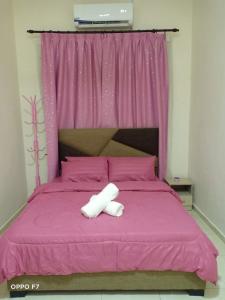 MerlimauMelissa Homestay Merlimau的粉红色的床和两条白色毛巾
