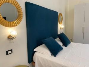 巴勒莫Amaris的一间设有一张蓝色床头板和镜子的床的房间