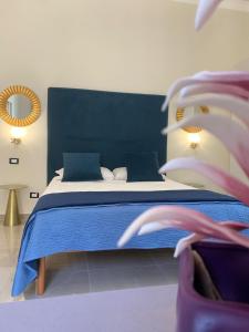 巴勒莫Amaris的一间卧室配有一张大床和蓝色的床罩