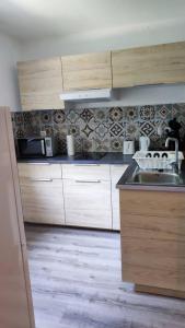 图卢兹Superbe appartement dans résidence avec piscine的厨房配有木制橱柜和水槽。