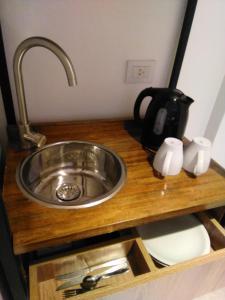 罗萨里奥Casa Be Suites的厨房柜台配有水槽和水壶