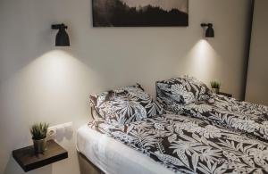 BrocēniRozenstein design apartment的一间卧室配有带枕头的床