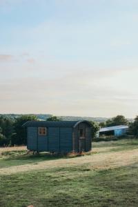 比迪福德Stunning Shepherd's Hut Retreat North Devon的蓝棚坐在田野里