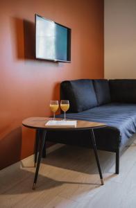 BrocēniRozenstein design apartment的沙发前桌子上放两杯葡萄酒
