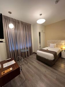 利马利马克酒店的酒店客房设有一张大床和一张桌子。