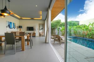 拉扬海滩度Sunpao Pool Villa by HCR的一间带桌子和游泳池的用餐室