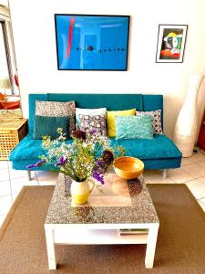 普罗旺斯艾克斯Allées Provençales的客厅配有蓝色的沙发和带鲜花的桌子
