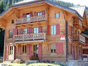 莫尔金斯瑞士小木屋住宿加早餐酒店的大型木制房屋设有红色门和阳台
