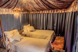 瓦尔扎扎特Ouednoujoum Ecolodge & Spa的带两张床和窗帘的房间