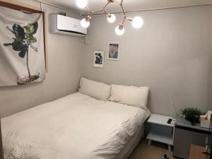首尔Rich House Dongdaemun的一间小卧室,配有白色的床和一张书桌