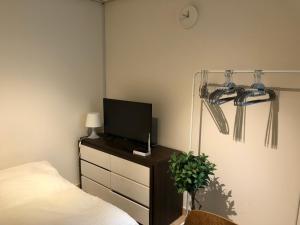 首尔Rich House Dongdaemun的一间卧室配有一张床,梳妆台上配有电视