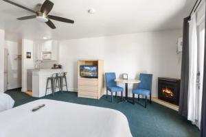 国王海滩Crown Motel的一间卧室配有一张床、一张桌子和一个壁炉