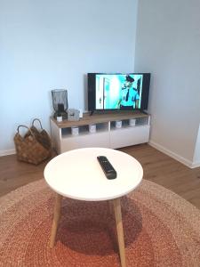 比尔森Zoo Karlovarská Apartment的客厅设有一张白色咖啡桌,配有电视。