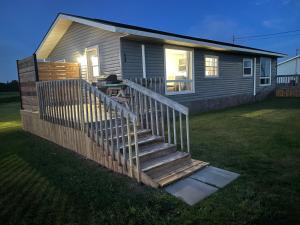 BordenNewly Renovated Confederation Bridge View Cottages的庭院里的小房子,有木楼梯