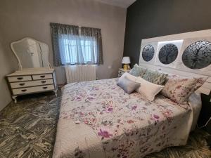 El Carpio de TajoCasa Flora - Casa rural con encanto的一间卧室配有一张床、梳妆台和镜子