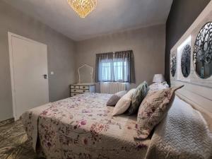 El Carpio de TajoCasa Flora - Casa rural con encanto的一间卧室配有一张带枕头的床和吊灯。