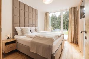 毛特恩多夫Granit Appartements的一间卧室设有一张大床和大窗户