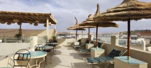 非斯里亚德阿尔玛坎庭院旅馆的一个带桌椅和遮阳伞的屋顶露台