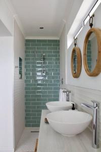 克莱因蒙德Seafront house with a view的浴室设有两个水槽和绿色的墙壁。