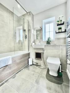 Farnham Royal3 bedroom lovely apartment in Slough with free parking的浴室配有卫生间、淋浴和盥洗盆。