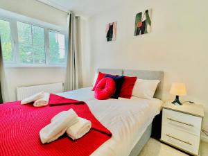 Farnham Royal3 bedroom lovely apartment in Slough with free parking的一间卧室配有一张带红色和蓝色枕头的床